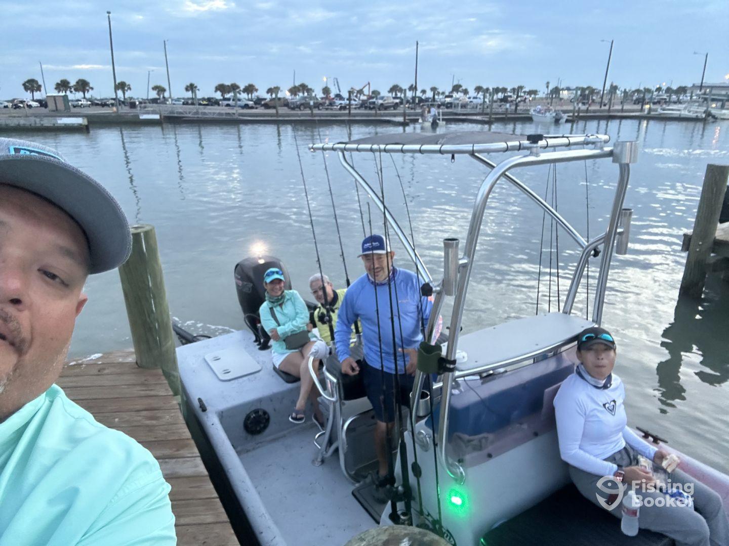 A group of anglers preparing for a fishing trip on a sleek boat at the marina, showcasing a vibrant fishing environment.