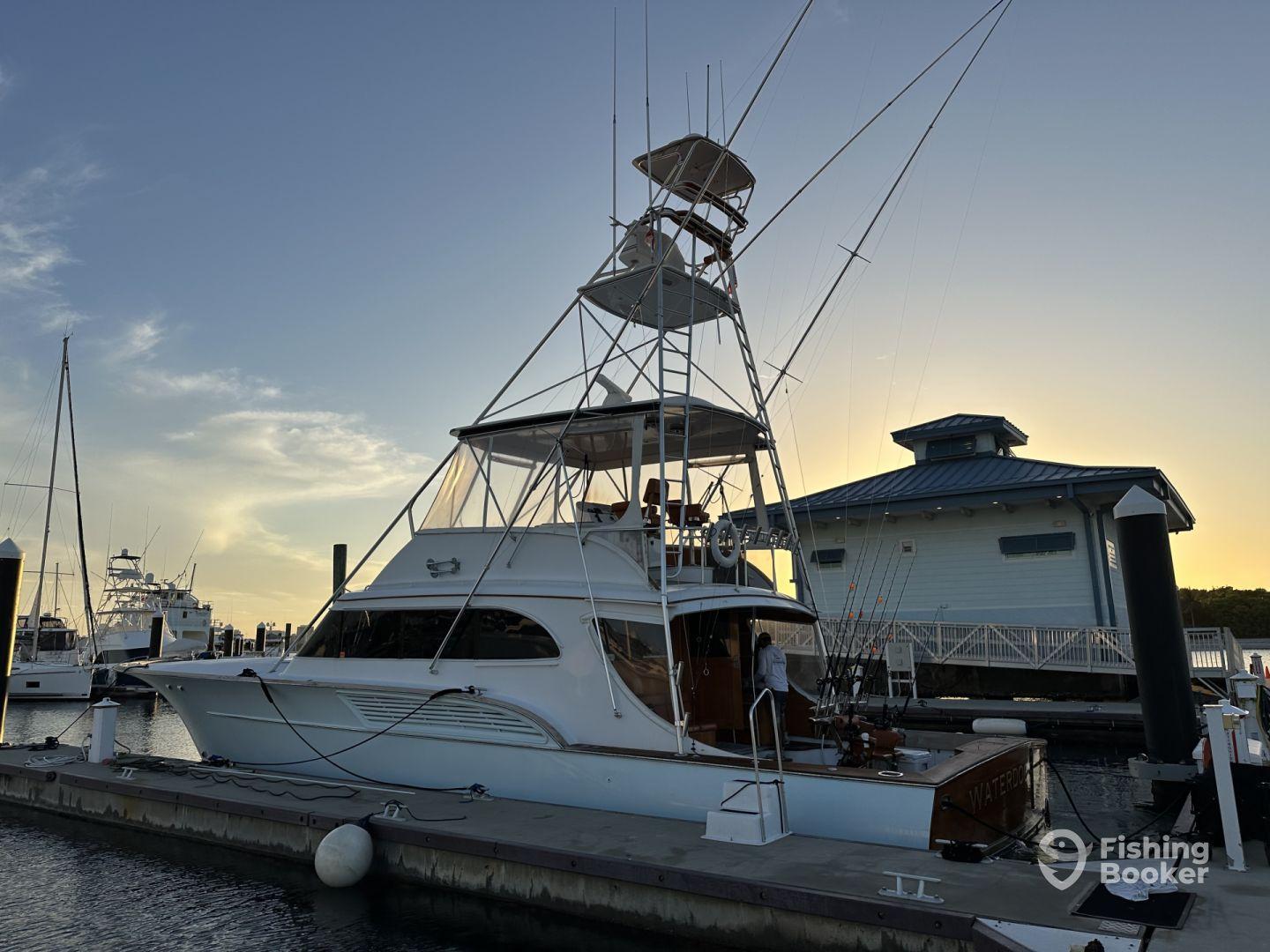 A sleek sportfishing yacht named 'Waterford' docked at sunset, showcasing its impressive design and fishing gear.