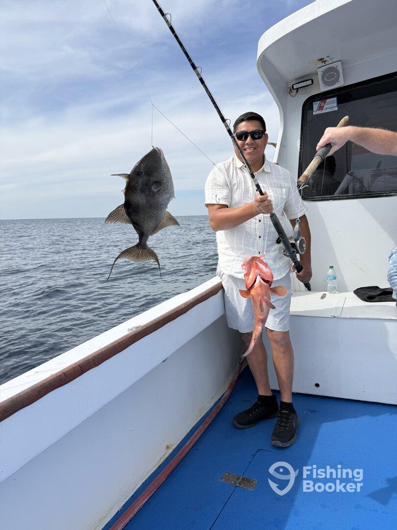 Angler proudly displaying a large fish while fishing on a boat, showcasing a successful day on the water.