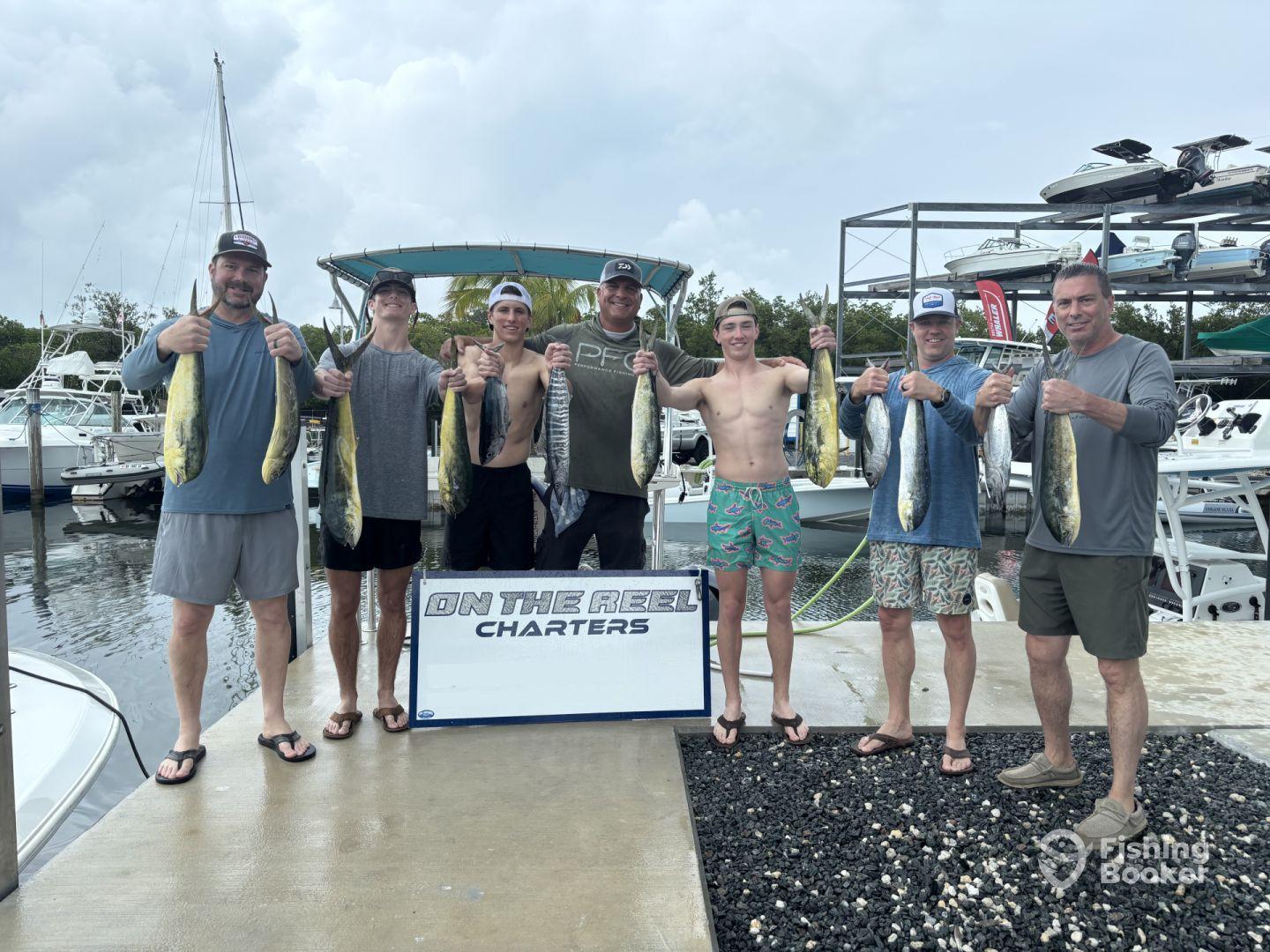 A group of anglers proudly displaying their catch of Mahi Mahi at the marina after a successful fishing charter.